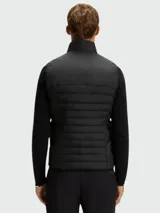 Chaleco acolchado de diseño técnico, con cierre frontal completo y cuello alto. Presenta un acabado liso y minimalista, ideal para capas intermedias o exteriores.