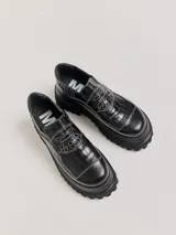 Mocasines con plataforma de goma negra, confeccionados en lona con estampa a cuadros en tonos violeta, amarillo y beige, y detalle de elásticos laterales ocultos.