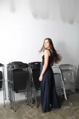 Pantalón jean azul oscuro de corte wide leg, con diseño holgado, bolsillos delanteros aplicados con detalles bordados y costuras verticales destacadas a lo largo de las piernas.