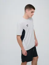 Remera deportiva Umbro modelo Vant, de color negro con paneles laterales grises y cuello redondo, diseñada para hombre.