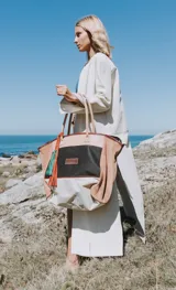 Tapado marrón de cuero con corte a la rodilla, mangas largas y aberturas laterales.