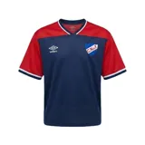 Remera de fútbol Umbro del Club Nacional de Football, modelo Match en color azul marino con mangas y canesú rojos. Cuenta con cuello en V con detalles blancos y azules, y el escudo del club bordado en el pecho.