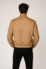 Campera tipo bomber de gamuza sintética en color negro, con cierre frontal metálico, cuello mao y puños y ruedo acanalados.