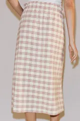 Falda midi recta de tiro medio con estampado a cuadros en tonos rosados y blancos sobre base beige, confeccionada en hilatura con mezcla de viscosa. Cuenta con cintura elástica ajustable con cordones y bajo recto.