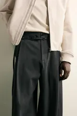 Pantalón de corte balloon fit confeccionado en tejido con viscosa. Presenta cintura ajustable con cinturón integrado, pliegues frontales, bolsillos laterales y bolsillos traseros de doble vivo. Cierre frontal con cremallera y botón.