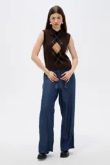 Chaleco de punto sin mangas con cuello polo, diseño de rombos estilo argyle en tonos marrón, negro y beige.