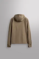 Chaqueta de hombre color marrón óxido con textura de pequeños cuadrados en relieve. Presenta cierre frontal de cremallera, capucha ajustable, bolsillos laterales con solapa y puños ajustables. El interior es de forro polar.