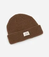 Gorro tipo beanie de punto texturizado color marrón, con dobladillo y etiqueta decorativa central con logo.