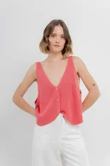 Chaleco tejido color coral con escote en V y cierre frontal con botones. Diseño de punto acanalado y corte holgado.