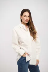 Camisa de corte clásico y calce holgado, con cuello camisero, cierre frontal con botones y mangas largas con puños abotonados.