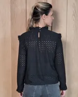 Polera de manga larga color blanco, confeccionada en algodón, con cuello alto tipo tortuga y detalles de volados en el cuello y en los puños.