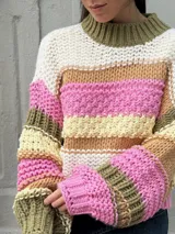Buzo de tejido de punto grueso con diseño de rayas horizontales multicolores en tonos blanco, rosa, verde oliva y beige. Presenta cuello redondo acanalado, mangas largas con puños ajustados y un corte holgado.
