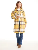 Sobrecamisa larga de tejido soft con estampado de cuadros en tonos celestes, beige y blanco. Presenta cuello con solapa, cierre frontal con botones, bolsillos aplicados en el pecho y mangas largas con puños abotonados.