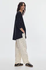 Vestido corto negro con estampado de lunares blancos, escote redondo y mangas 3/4.