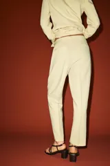 Pantalón de tiro alto color fucsia, de corte recto, con bolsillos delanteros, falsos bolsillos de vivo en la espalda y raya marcada en las perneras. Cierre frontal con cremallera, botón interior y gancho metálico.