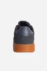 Zapatillas urbanas negras con suela marrón.