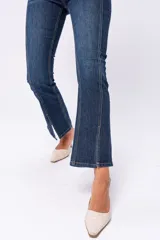 Pantalón de jean azul oscuro, corte semi Oxford, con costuras verticales en el frente.