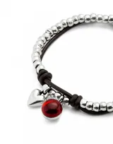 Pulsera Uno de 50 con doble tira, una de cuero marrón y otra de cuentas plateadas. Incluye un dije de corazón plateado y un dije de cristal de Murano rojo.