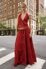 Falda midi color rojo oscuro con diseño de paneles fruncidos, cintura elástica con cordón ajustable y abalorios decorativos.