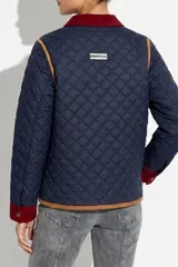 Campera capitoneada azul marino con diseño acolchado en rombos. Presenta detalles en pana color bordó en el cuello, puños y tapas de los bolsillos frontales. Cuenta con ribetes en color tostado, cierre frontal con botones y forro interior de polar.