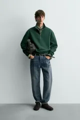 Sudadera de algodón azul con cuello alto y cierre frontal de cremallera de un cuarto. Presenta un corte regular y puños y bajo en rib.