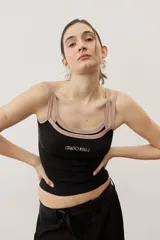 Musculosa de tejido de punto acanalado color negro, con doble tirante y ribetes en tono tostado. Cuenta con un bordado frontal con texto.
