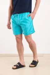 Short de baño verde con cintura elástica y cordón ajustable.