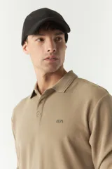 Polo de manga larga color beige con textura, fit regular, logo estampado y puños.