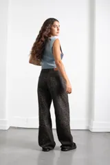 Pantalón de jean con estampado animal print en tonos oscuros, de corte recto y tiro medio. Cuenta con bolsillos traseros y etiqueta de cuero sintético con el logo de la marca en la cintura.