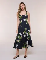 Vestido midi evasé de algodón color negro con estampado floral blanco y verde, de la marca Julia Jordan. Presenta escote recto, breteles anchos y espalda en punto smock. Incluye bolsillos laterales y forro interior de poliéster.