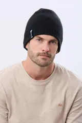Gorro tejido de punto reversible en dos colores, azul marino y negro, con etiqueta lateral de la marca.