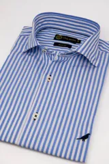 Camisa de vestir Club House modelo Hudson, corte slim fit, con diseño de rayas verticales celestes y blancas. Cuenta con cuello estructurado, cierre frontal de botones y un pequeño bordado de un ave en la parte inferior.