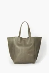 Bolso tipo tote de cuero vacuno en tono gris verdoso, con doble asa de hombro, acabado sin forrar y cierre con broche imán.