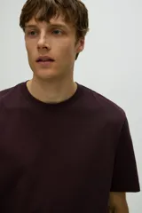 Remera de cuello redondo y manga corta, confeccionada en algodón de corte estándar con diseño liso.