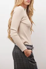 Buzo de morley color crema, con cuello bote y manga larga. Presenta un diseño de punto acanalado y un detalle de franja horizontal en el pecho.