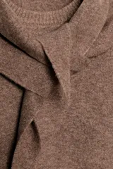 Jersey de punto color marrón, con cuello redondo y detalle de pañuelo integrado a tono. Presenta manga larga y diseño con aberturas laterales en el bajo.