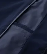 Campera tipo bomber color beige, con cierre frontal de cremallera, cuello estilo béisbol, puños y ruedo acanalados. Cuenta con bolsillos laterales con cierre y tecnología repelente al agua.