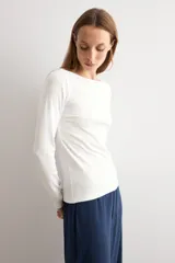 Remera de manga larga en color blanco, con escote bote y corte ajustado al cuerpo.