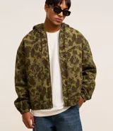 Campera con capucha y cierre frontal, confeccionada en sarga con estampado camuflado. Tiene manga larga con sisa desplazada, puños ajustados, bolsillo canguro y bajo con elástico.