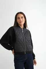 Campera tipo bomber con frente acolchado en diseño de rombos y mangas de tejido de punto acanalado. Presenta cierre frontal metálico y cuello, puños y ruedo en tejido elástico.