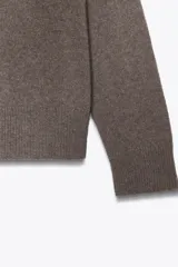 Jersey básico de cuello redondo y manga larga, confeccionado en una mezcla de cashmere y lana, con diseño de corte holgado y puños acanalados.