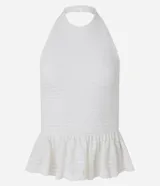 Top blanco de tejido piquet texturizado, con cuello halter y peplum con volado en la cintura.