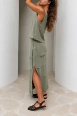Falda larga color beige de lino tusor, con diseño de recortes en capas con detalles desflecados, de calce relajado y caída natural.