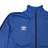 Conjunto deportivo Umbro de campera y pantalón en color gris. La campera es de cuello alto, con cierre frontal completo y bolsillos laterales con cierre. El pantalón cuenta con cintura elástica y bolsillos laterales. Ambos presentan detalles de franjas negras en los costados y el logo de la marca bordado.