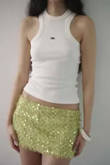 Minifalda de tiro bajo confeccionada en tejido texturizado color verde lima, con apliques de lentejuelas circulares brillantes.