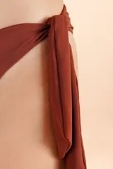 Bombacha de bikini color terracota con diseño asimétrico y detalle de lazo lateral para anudar.