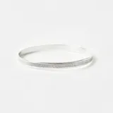 Esclava rígida de plata 925 con acabado satinado y textura lineal. Diseño minimalista de banda plana con 5mm de ancho.