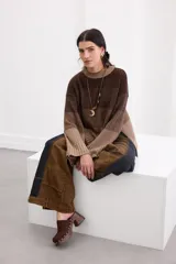 Sweater de punto con diseño en bloques de tonos marrones y tostados, cuello redondo y mangas largas amplias.