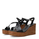 Sandalias de plataforma de corcho trenzado y taco chino, color suela, con tiras cruzadas de cuero y cierre de hebilla en el tobillo.