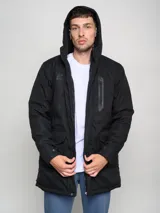 Parka larga gris con capucha, cierre frontal con cremallera y botones a presión, múltiples bolsillos y logo de Umbro en el pecho.